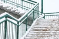 Metal staircase with railings on the street. The steps and railings of the stairs are covered with snow. Gently descend Royalty Free Stock Photo