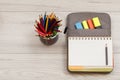 Metal stand for pencils with color pencils, open exercise book o Royalty Free Stock Photo