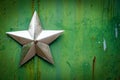 Metal star on green background