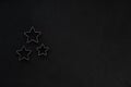 Metal stars on black festive background. Baking molds. Cookie cutters. Flat lay, top view Royalty Free Stock Photo