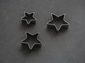 Metal stars on black festive background. Baking molds. Cookie cutters. Flat lay, top view Royalty Free Stock Photo