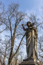 Metal statue featuring figures of an angel holding a cross Royalty Free Stock Photo