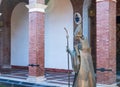 Metal statue of walking bishop decorating patio of catholic church in Italy