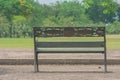 Metal steel old fashioned bench chair on concrete floor with green natural background. Royalty Free Stock Photo