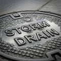 Metal storm drain cover with the words STORM DRAIN embossed on the Royalty Free Stock Photo