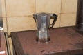 Metal stovetop coffee maker on a cast iron wood burner stove