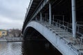 Metal structure of the bridge over city river. Stone coast of Moskva River Royalty Free Stock Photo