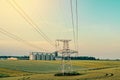 Metal support is a pillar of a high-voltage line in the field. Big elevator on the background. Industrialization of agriculture Royalty Free Stock Photo