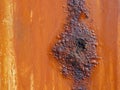 Metal surface with an orange coating that rusts with age