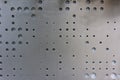 Metal surface with round different sizes holes for ventilation. Textured metal plate