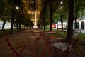 Metal tables with a wooden surface and four chairs on a pedestrian street