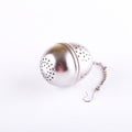 Metal tea strainer placed on white board Royalty Free Stock Photo