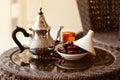 A metal teapot, a glass with a drink, dates and an Arabic rosary lie on the table. Ramadan Kareem