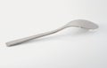 Metal teaspoon on white specular surface