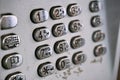 Metal telephone dial in the public phone booth with black letters and numbers on the silver plated buttons Royalty Free Stock Photo