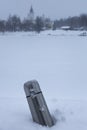 a metal thermos with an open lid stands on a snow