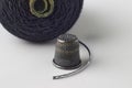 Metal thimble, sewing needle and spool of black thread on a white background Royalty Free Stock Photo