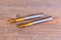 Metal threading taps. Tool for processing metal on a wooden board Royalty Free Stock Photo