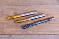 Metal threading taps. Tool for processing metal on a wooden board. Royalty Free Stock Photo