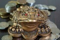 A metal toad next to a stack of coins. Royalty Free Stock Photo