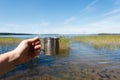 Metal touristic tea cup in man hand on outdoor background. Royalty Free Stock Photo