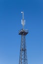 Metal tower with antennas for mobile cell phone communications against blue sky Royalty Free Stock Photo