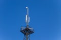 Metal tower with antennas for mobile cell phone communications against blue sky Royalty Free Stock Photo