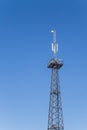 Metal tower with antennas for mobile cell phone communications against blue sky Royalty Free Stock Photo