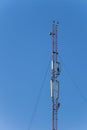 Metal tower with antennas for mobile cell phone communications against blue sky Royalty Free Stock Photo