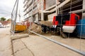 Metal trailer coupling of compressor peeks through wire fence on construction site