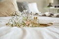 Metal tray with bottles of perfume and flowers on bed Royalty Free Stock Photo