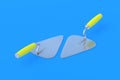 Metal trowels with yellow handle on blue background