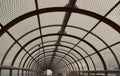 Metal tunnel bridge with wooden walkway. Royalty Free Stock Photo