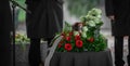 Metal urn or funeral container with ash of a deceased person at a memorial service. Undertakers seen in the back and a beautiful Royalty Free Stock Photo