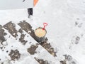 A metal vedto with salt stands outside on the steps on a snowy winter day