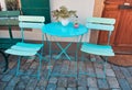 Light blue table and chairs out on paved street Royalty Free Stock Photo