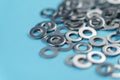 Metal washers on a blue bright background. Technical spare part