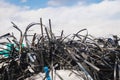 Metal waste against a blue sky with clouds, industrial trash