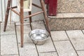 A metal water bowl stands outside, a street drinker for stray dogs and cats.