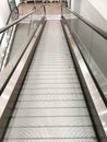 Metal step walk way moving shopping trolley escalator. Nobody going down subway. clean stainless steel and clear mirror interier c Royalty Free Stock Photo