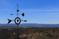 Metal weather vane with mountains in the background