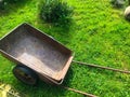 Metal wheelbarrow for garden maintenance. pink, old, rusty cart for transporting fertilizers, potatoes, orchard fruits. long Royalty Free Stock Photo