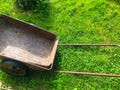 A metal wheelbarrow for transporting products and fertilizers stands on the green grass. a wheelbarrow for garden work. gardener,