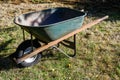 Metal wheelbarrow with a warn out tire, well used gardening tool