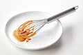 Metal whisk with dripping caramel sauce