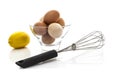 Metal whisk with fresh eggs and lemon