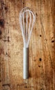 Metal whisk on a wooden background