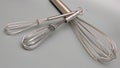 Metal whisks on gray background Royalty Free Stock Photo