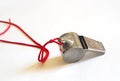 Metal whistle on a red cord