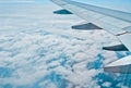 Metal wing of the aircraft on the background of blue sky and white clouds. Royalty Free Stock Photo